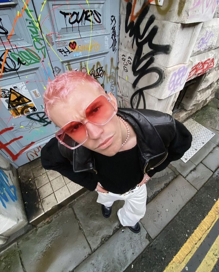 a man with pink hair and sunglasses on the street