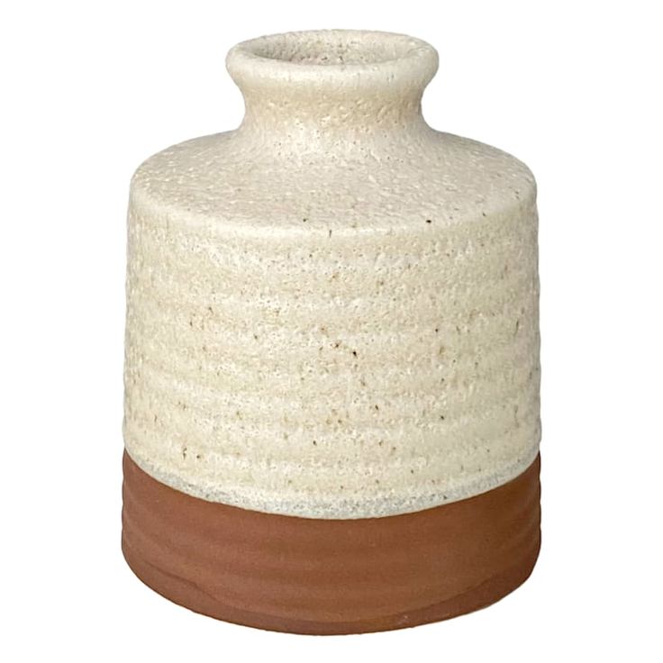 a white and brown vase sitting on top of a table