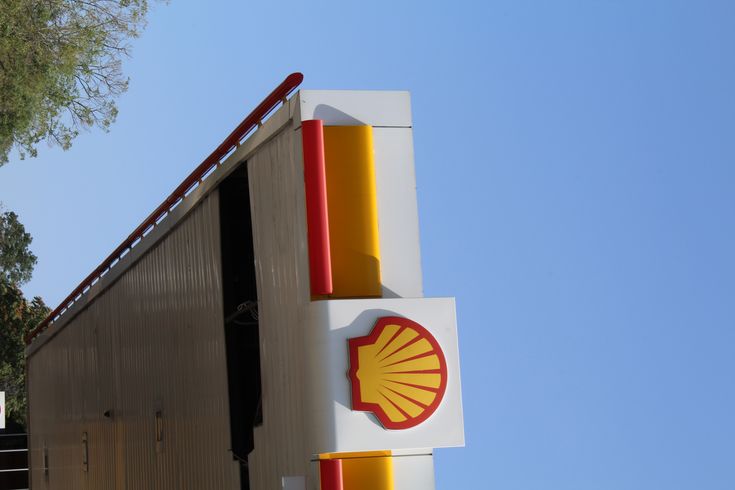 a shell gas station sign with a blue sky in the background