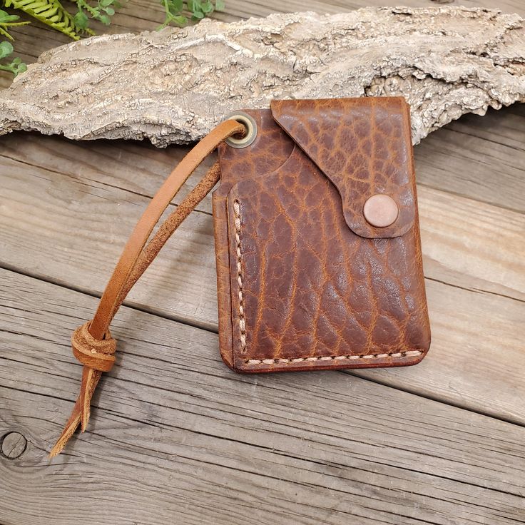 The EDC Wallet is a convenient and compact solution for carrying your essential cards and cash. Its front pocket design and snap closure provide security, while the leather lanyard allows for easy attachment to bags or belts. Made in Utah, it features a folded cash pocket and card slot that can hold both cards and cash, making it the perfect wallet for on-the-go use. Brown Travel Card Holder With Key Clip, Card Holder With Card Slots For Daily Use, Rectangular Badge Holder With Card Slots For Everyday Use, Rectangular Badge Holder With Card Slots, Leather Trifold Wallet With Key Chain Holder For Everyday, Leather Trifold Wallet With Key Chain Holder, Leather Card Holder With Belt Clip For Everyday, Rectangular Trifold Wallet With Belt Clip For Everyday Use, Everyday Use Trifold Wallet With Belt Clip