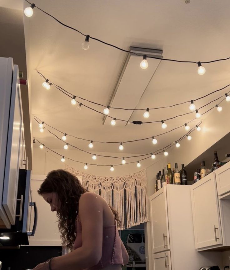 a woman standing in a kitchen preparing food on top of a counter next to an oven