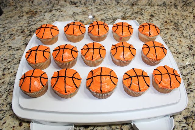 cupcakes with orange frosting decorated like basketballs