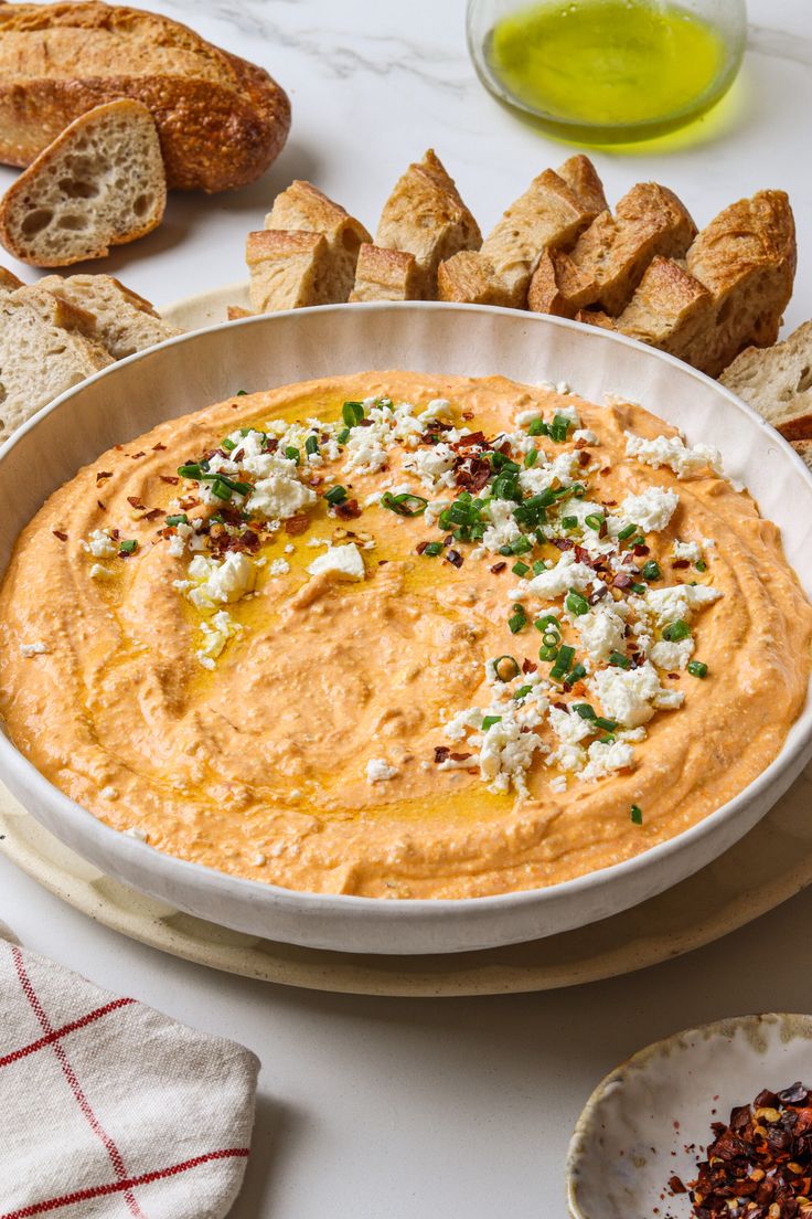 a bowl of hummus and bread on a table