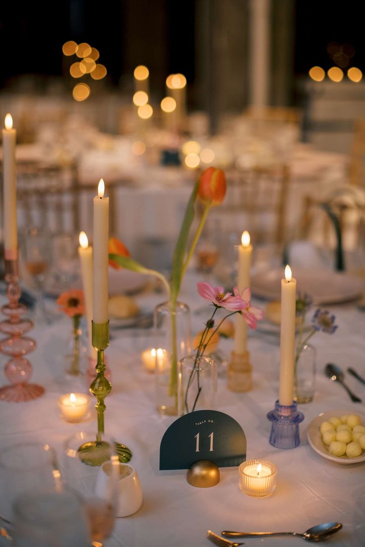 the table is set with candles, plates and utensils for an elegant dinner