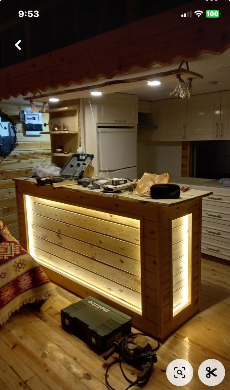 an image of a kitchen counter made out of wood with lights on the top and below it