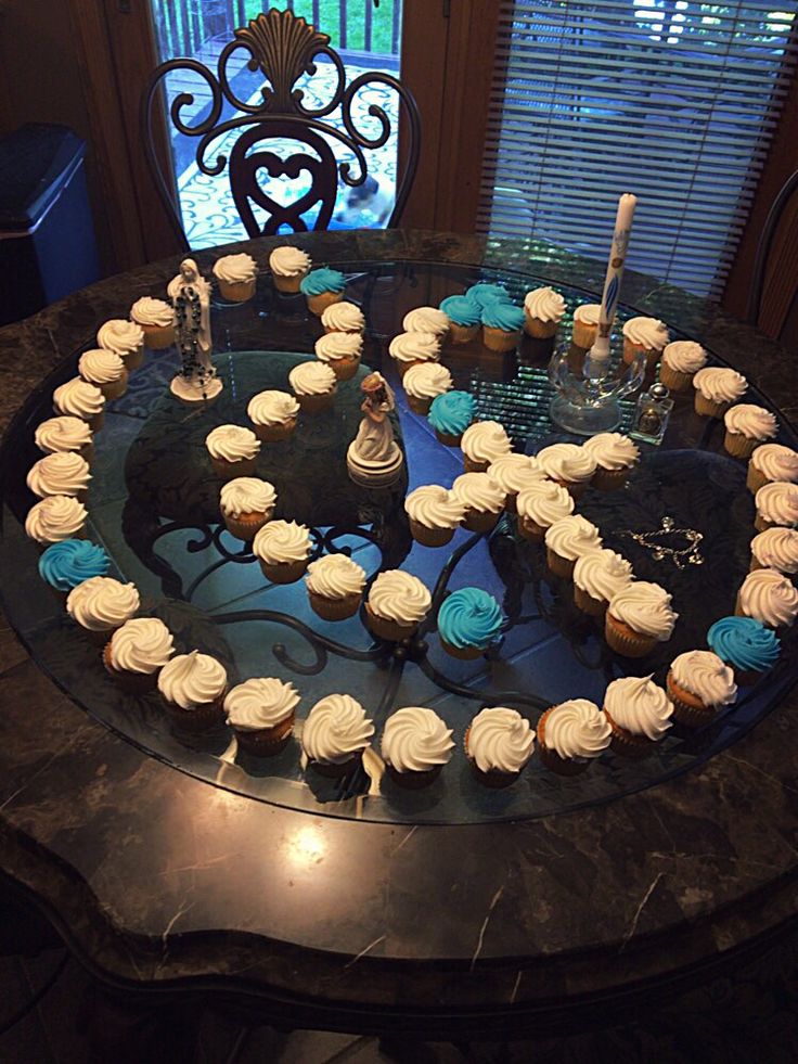 cupcakes arranged in the shape of a heart on a table