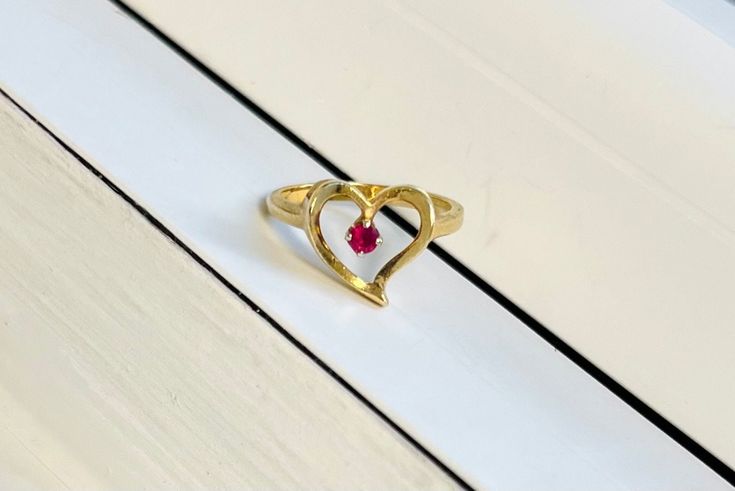 A Vintage 14k Gold Heart Ring Set with Ruby All items are XRay and Acid tested to ensure metal authenticity.  Weight: 3.2 grams Ring Size: 5.5 (resizing available upon request) Heirloom Gold Ruby Ring For Valentine's Day, Valentine's Day Heart Cut Gold Ruby Ring, 14k Gold Heart-shaped Solitaire Ring, Heart-shaped 14k Gold Ruby Promise Ring, Heart-shaped Yellow Gold Ruby Ring For Wedding, Heart-shaped Yellow Gold Ruby Wedding Ring, Heirloom Yellow Gold Ruby Ring For Valentine's Day, Elegant Heart Shaped Ruby Ring In Yellow Gold, Anniversary Yellow Gold Ruby Ring With Heart Shape