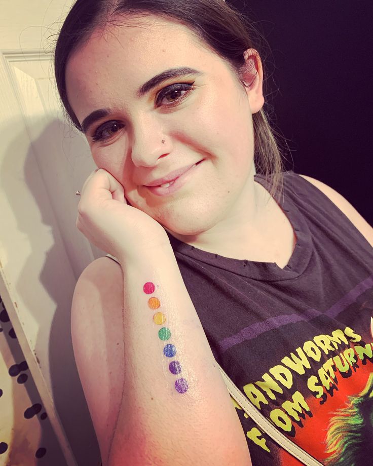 a woman with a rainbow tattoo on her arm