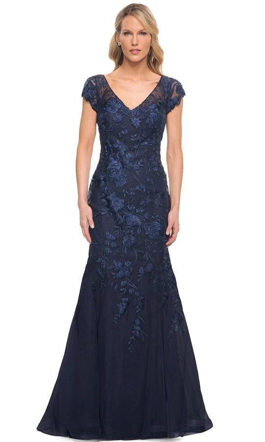 Take center stage in this dazzling look by La Femme 30269. This lace gown's V neckline and sheer cap sleeves stand out. A sheer laced illusion reveals a mid-open back lining and zips up the back. The skirt has a full length hem with a train and a mermaid silhouette. With this La Femme dress, you'll look sophisticated and classy. The model is dressed in navy. Velvet Sheath Dress, Dress Couture, Long Evening Gowns, Dresses Style, Couture Candy, Lace Evening Dresses, Mermaid Silhouette, Mermaid Gown, Mother Of The Bride Dress