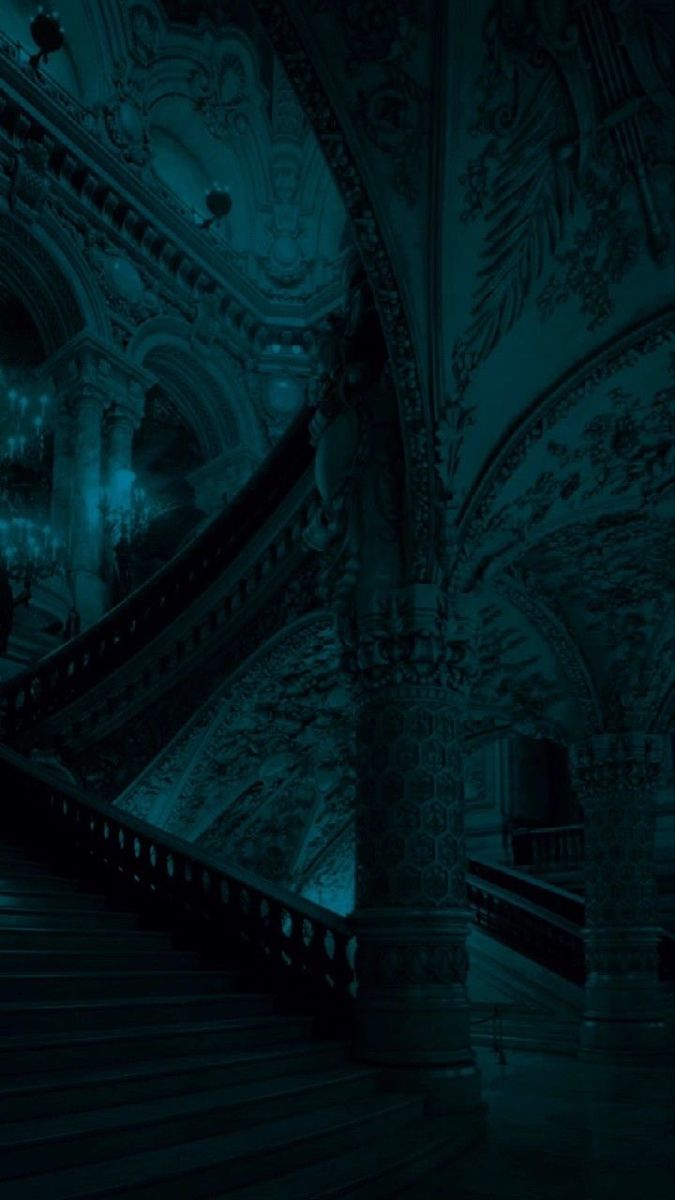 an empty staircase in a building lit up by blue light from the ceiling and chandelier