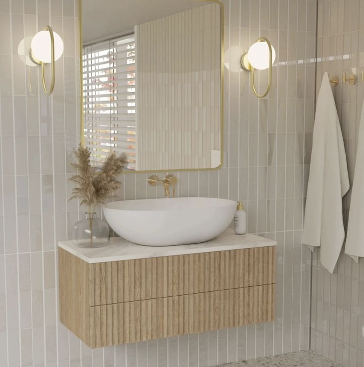 a white sink sitting under a bathroom mirror