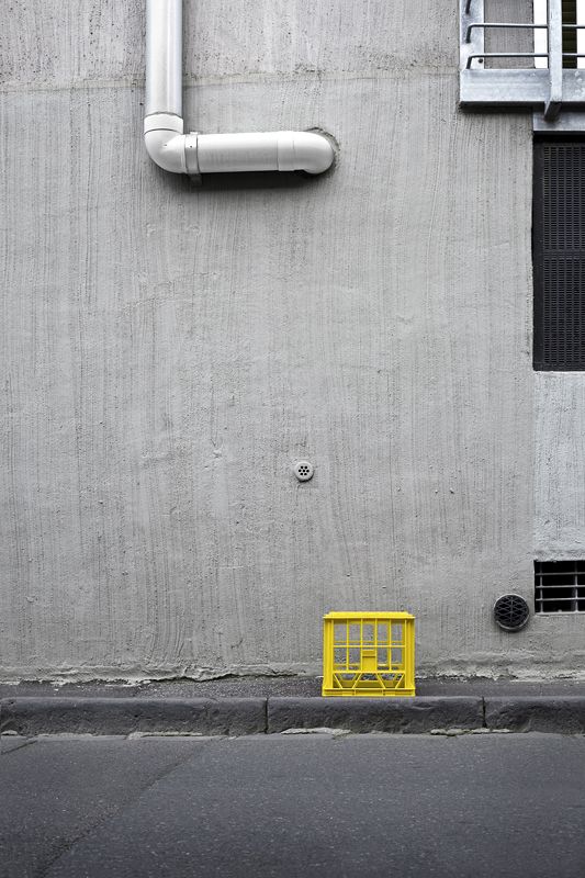 a fire hydrant sitting next to a yellow box on the side of a building