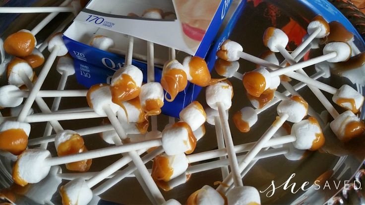 marshmallows are arranged on sticks in a bowl