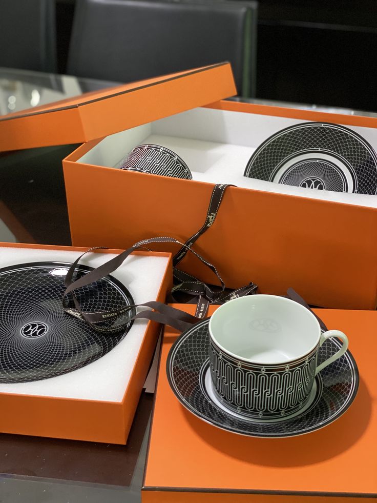 an orange box with some cups and saucers in it