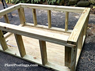 a wooden planter box sitting on the ground