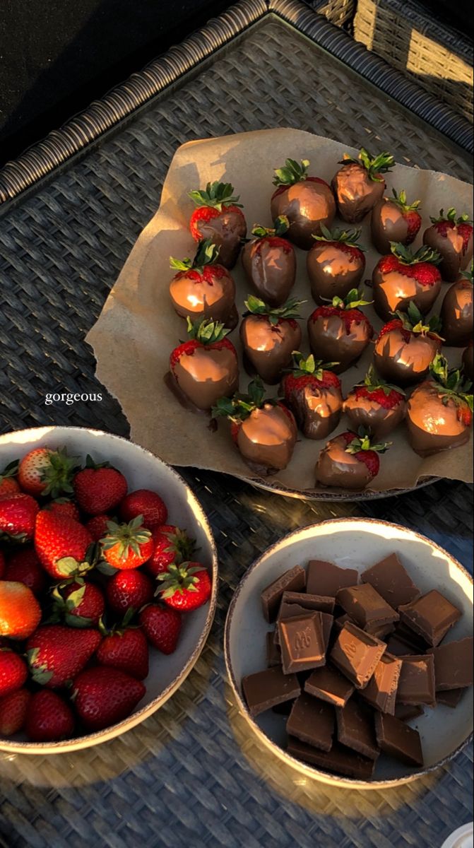 chocolate covered strawberries and strawberries in bowls on a table