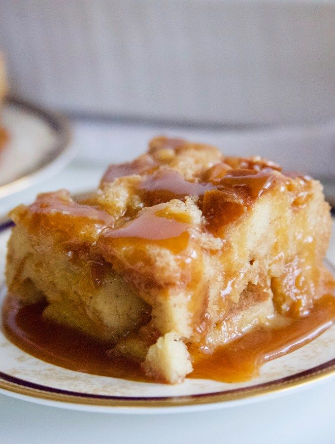 a piece of bread pudding on a plate with caramel sauce