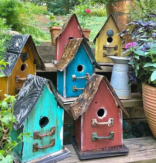 colorful bird houses are lined up in the garden