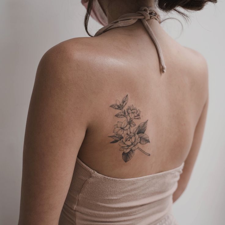 a woman with a flower tattoo on her back