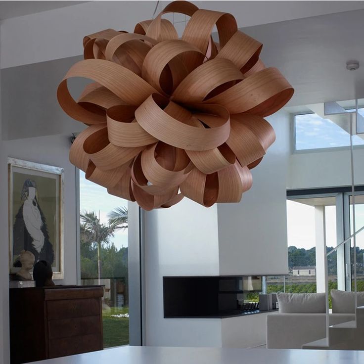 a large wooden chandelier hanging from the ceiling in a living room next to a dining room table