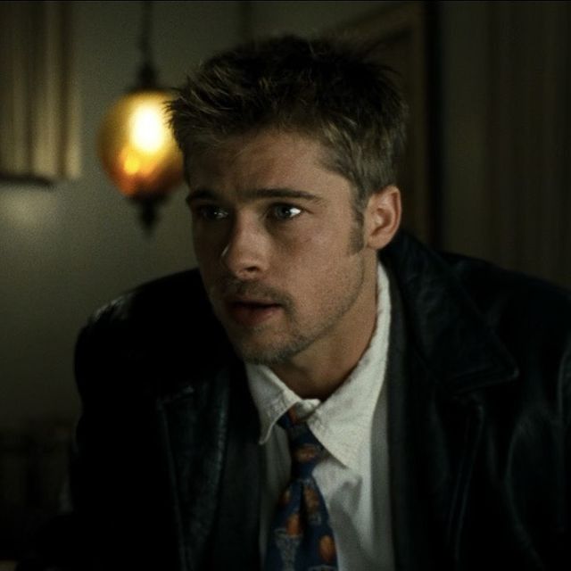 a young man in a suit and tie looking at the camera with serious look on his face