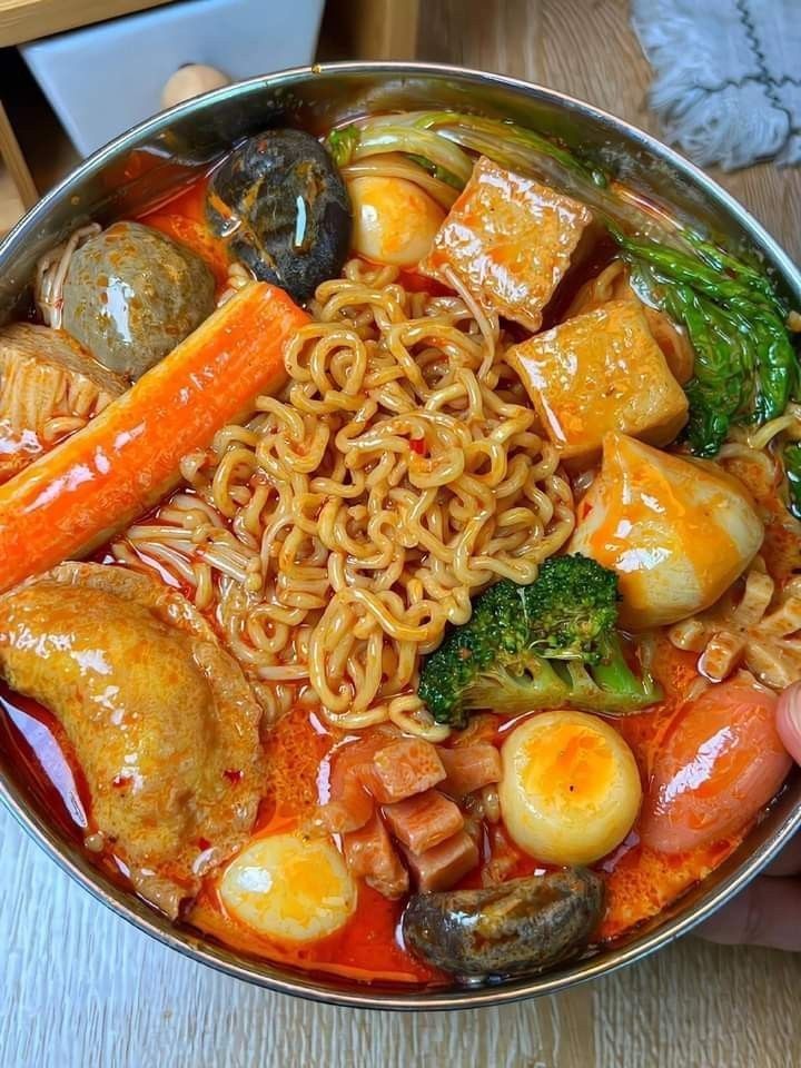 a bowl filled with noodles, vegetables and meats