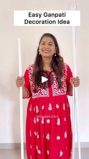 a woman in a red dress holding a sign with the words easy ganpai decoration idea