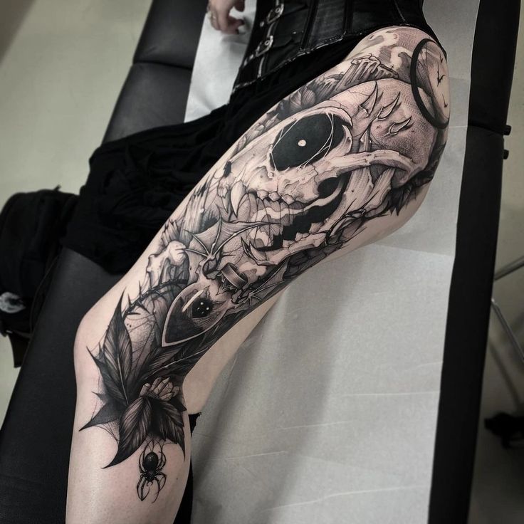 a woman's leg with a skull and flowers tattoo design on it, sitting in a chair