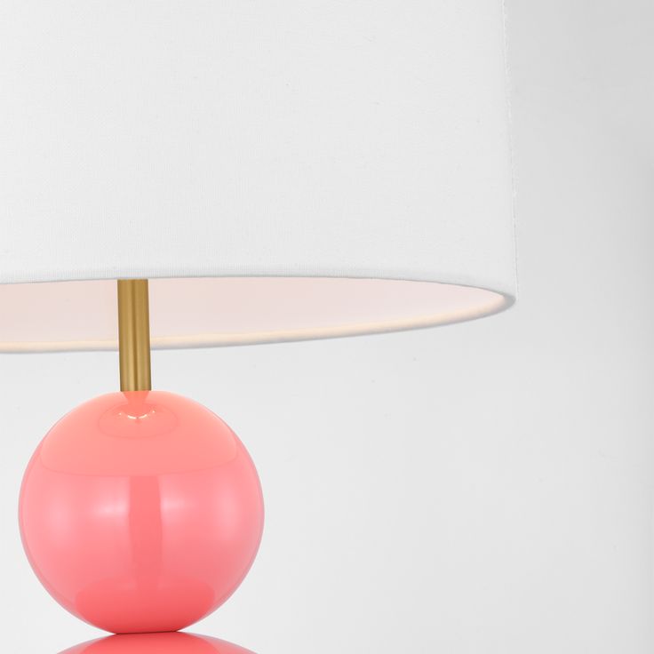 a pink table lamp with a white shade on it