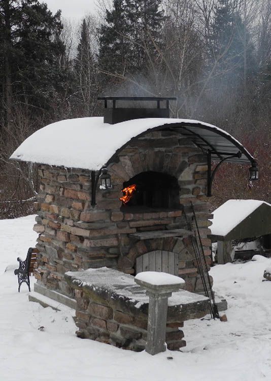 an outdoor oven with snow on the ground