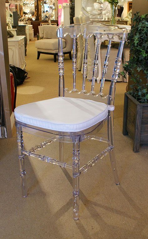 a white chair sitting on top of a carpeted floor in front of a store