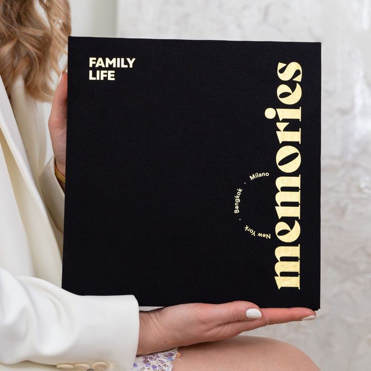 a woman holding up a book that says, mom's on the front cover