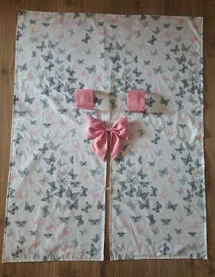 a pink bow on top of a white sheet with butterfly designs and bows around it