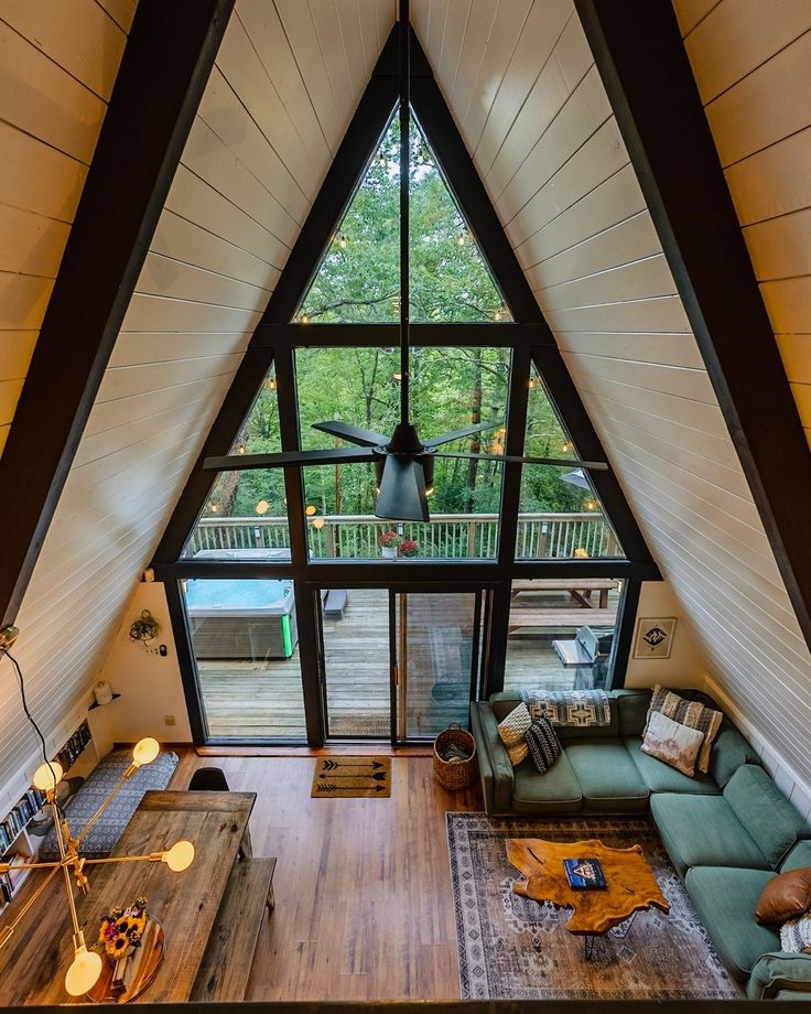 a living room filled with furniture and a large window in the middle of it's roof