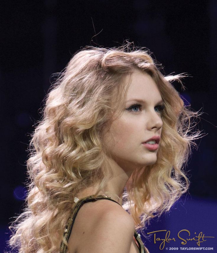 a close up of a person wearing a dress with curly hair and blue eyeshadow