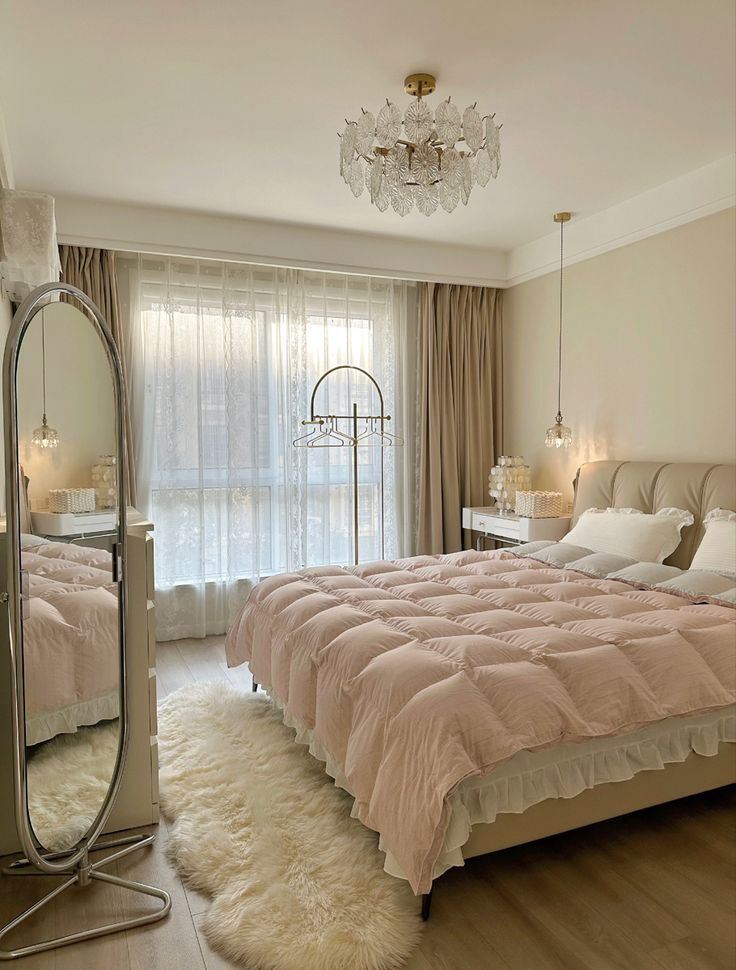 a bedroom with a bed, mirror and chandelier