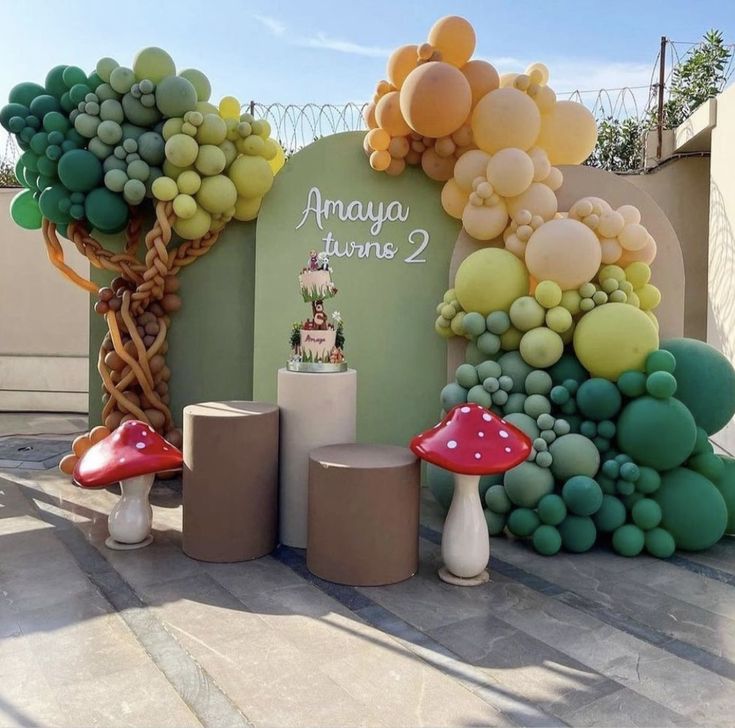 an outdoor display with balloons, mushrooms and trees