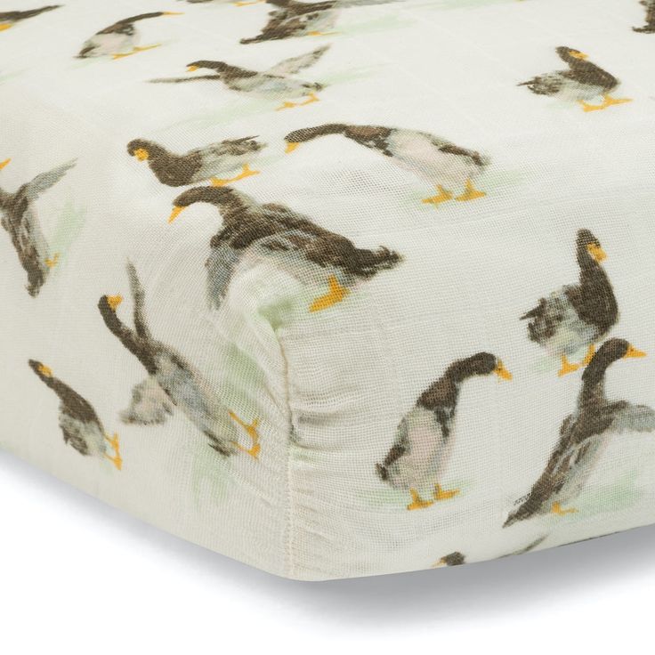 a close up of a bed sheet with birds on it