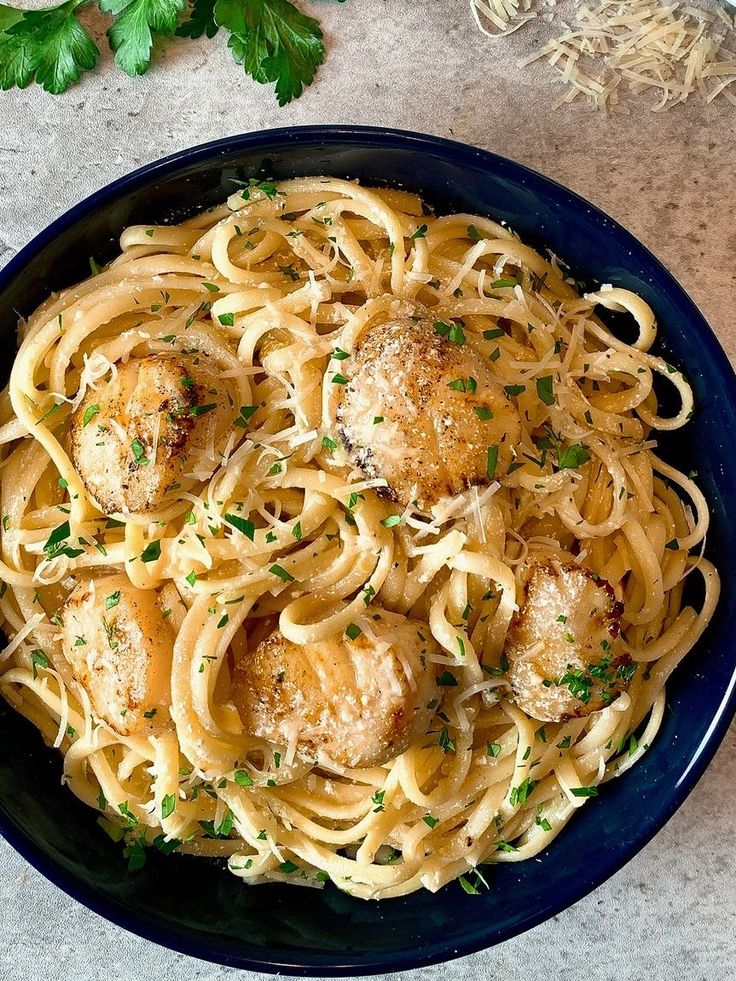 a plate of pasta with meatballs and parsley