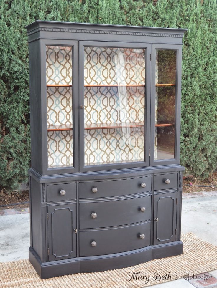 an old china cabinet with glass doors on the front and bottom, painted in dark gray