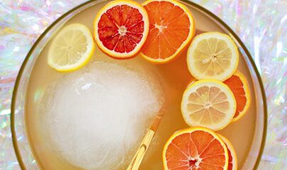 oranges and lemon slices in a bowl with ice