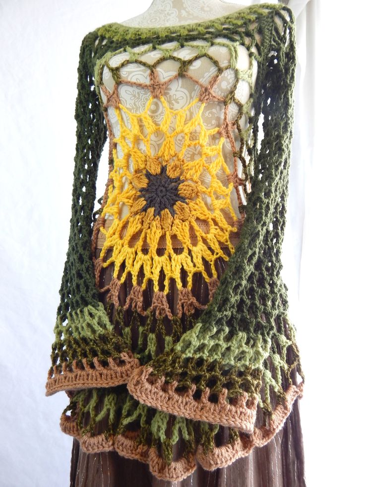 a crocheted top with sunflowers on it is hanging from a mannequin