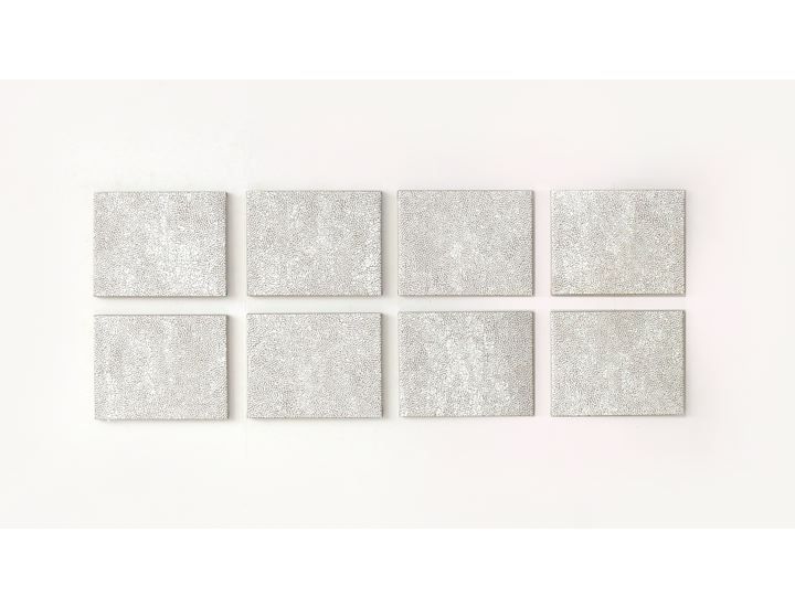 six square white tiles arranged in rows on a wall