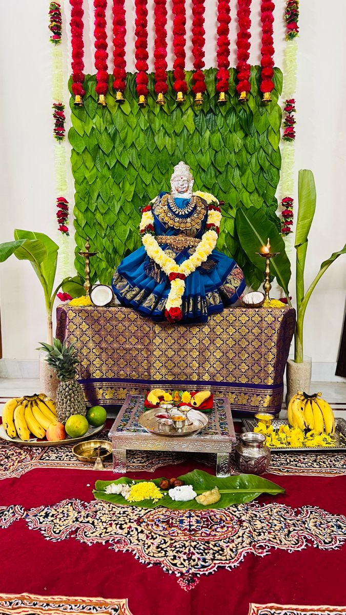 a buddha statue sitting on top of a wooden bench surrounded by bananas and other decorations