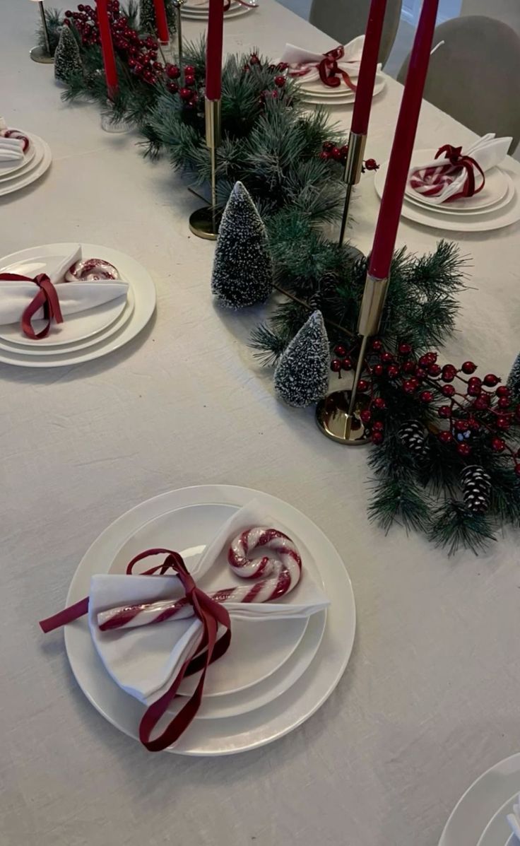 a white table topped with plates covered in christmas decorations