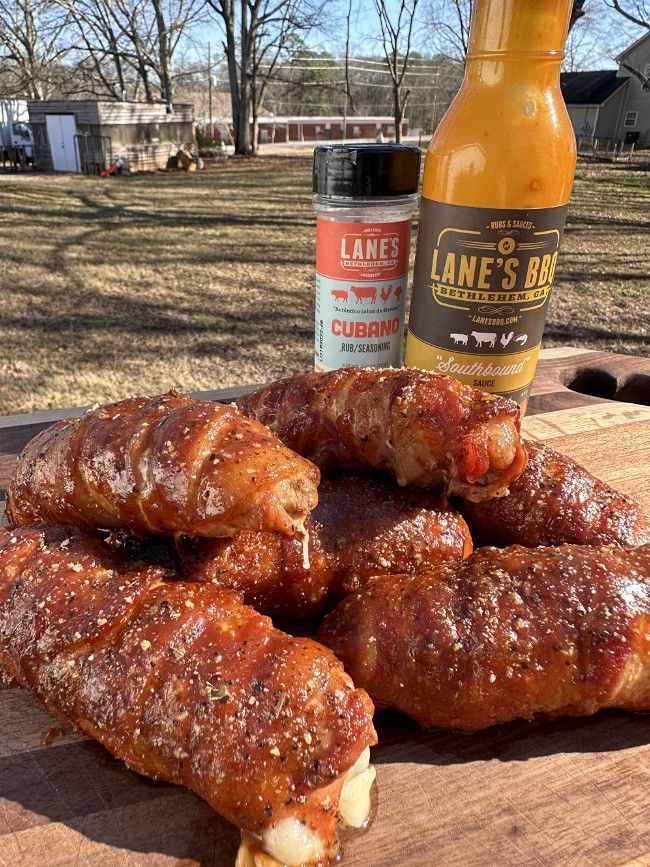 several pieces of meat sitting on top of a wooden cutting board next to a beer bottle