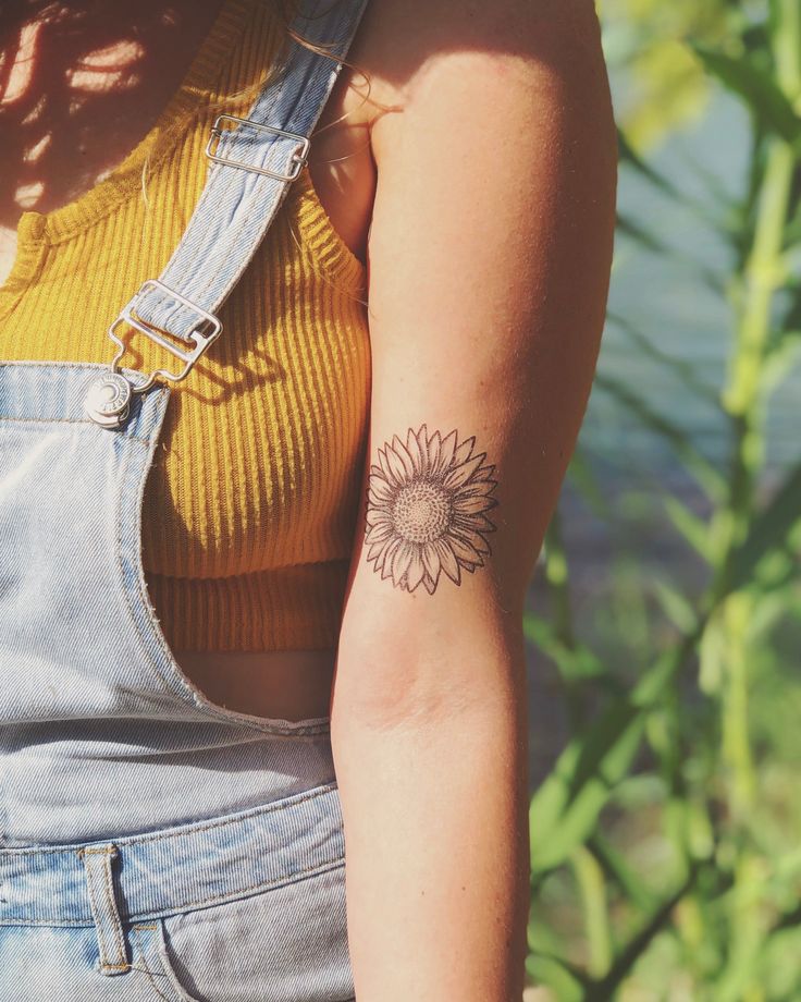 a woman with a sunflower tattoo on her arm