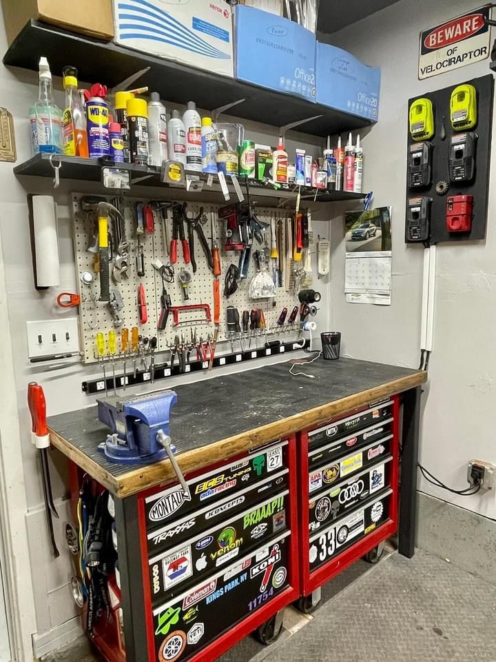 a workbench with lots of tools on it in a garage or repair shop