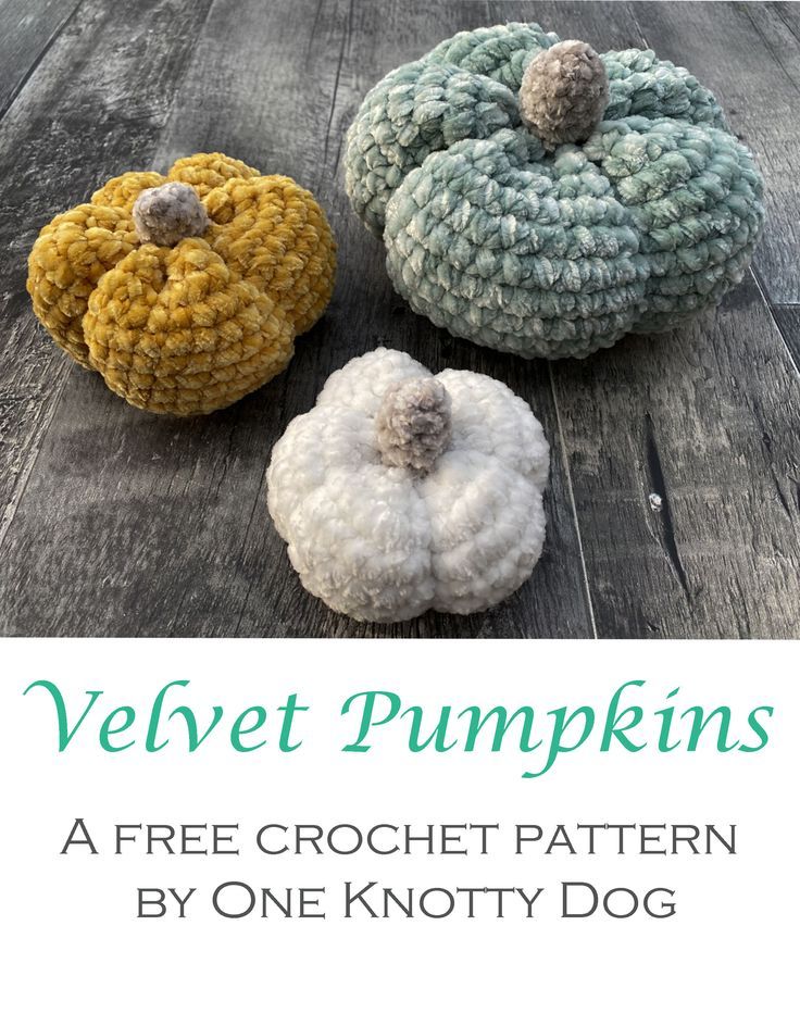 three crocheted pumpkins sitting on top of a wooden table