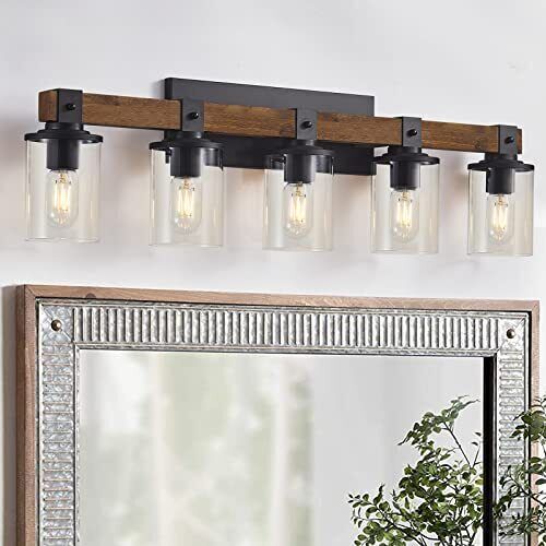 a bathroom vanity light with three lights and a mirror on the wall next to it